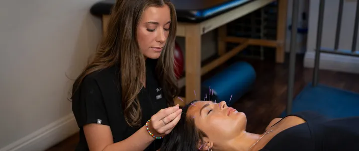Chiropractor Phoenix AZ Emillie Castrichini Applying Dry Needling to Patient